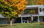 Students in autumn walking past modern STEM building