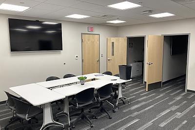 Large office with table, chairs, and TV monitor